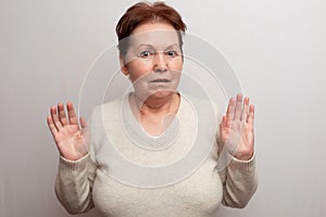 Adult woman on a white background in a light sweater. Emotions