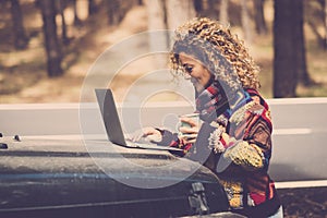 Adult woman work outdoor with laptop computer in the outdoors nature with roaming technology - digital nomad free lifestyle for