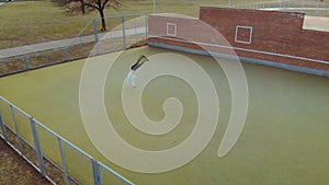 Adult, young man in white jacket shows acrobatic flip