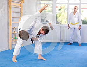 Adult and young men training judo fight