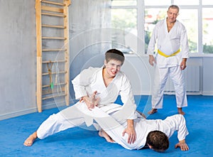 Adult and young men training judo fight