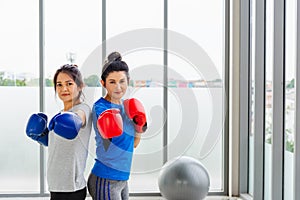 Adult and young woman smiling sports fitness boxer wearing gloves practicing kick on boxing