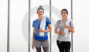 Adult and young woman smiling with towel around neck after yoga and exercise