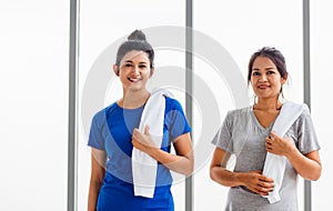 Adult and young woman smiling with towel around neck after yoga and exercise