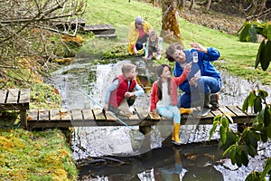 Adults With Children On Bridge At Outdoor Activity Centre