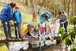 Adults With Children On Bridge At Outdoor Activity Centre