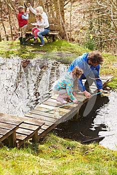 Adults With Children On Bridge At Outdoor Activity Centre