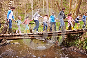 Adults With Children On Bridge At Outdoor Activity Centre photo