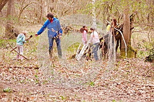 Adults And Children Building Camp At Outdoor Activity Centre