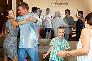 Adults and children dancing at a party at home