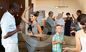 Adults and children dancing at a party at home