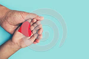 Adults and children hands holding a red heart, healthcare, love and family insurance concept, world heart day, world health day, f