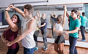 Adults dancing bachata together in dance studio