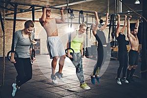 Adults doing chin ups for cross fit training