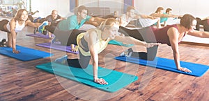 Adults having yoga class in sport club