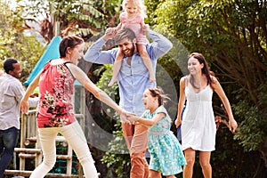 Adults and kids having fun playing in a garden