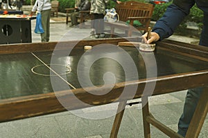 Adults play air hockey on the street, close-up hands