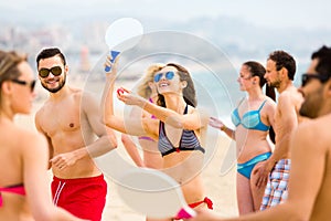 Adults playing paddle games on beach