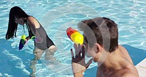 Adults shooting shooting water guns at each other