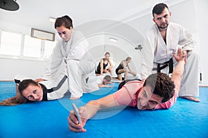 Adults taking photos while practicing taekwondo holds