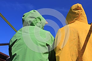 Adults wearing brightly colored raincoats