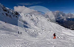 Advanced skiers exploring off piste terrain with breathtaking landscape around.