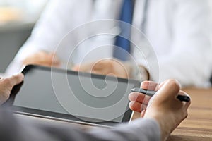 Advanced technology in the modern hospital. Patient puts an electronic signature on a health insurance contract using a