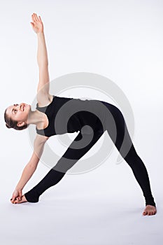 Advanced yoga posture, demonstrated by bloden girl, dressed in black, on white background