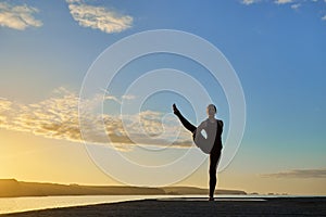 Advanced yoga posture in silhouette in a sunset