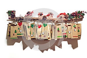 Advent calendar bags hanging on the decorated branch