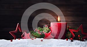 Advent candle, fir tree branches and holiday star decorations in snow against wooden background. Christmas card