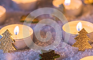 Advent and christmas candles with golden shiny christmas trees on snow