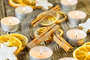 Advent and Christmas season composition with candle flames, orange slices, cinnamon and star shape cookies