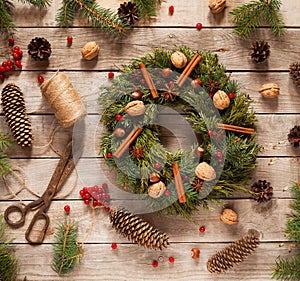 Advent Christmas wreath decoration with natural decorations, pine cones spruce, nuts, candied fruit on wooden background