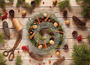 Advent Christmas wreath with natural decorations, pine cones spruce, nuts, candied fruit on wooden rustic background