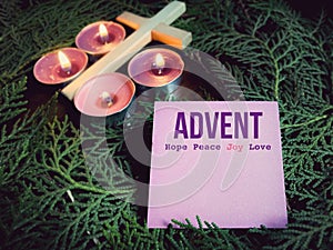 Advent hope peace joy love on paper with cross, candles and wreath background. Christmas preparation or Advent season concept.