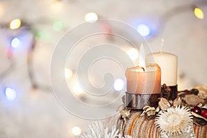 Advent wreath with burning candle and white background with Christmas lights