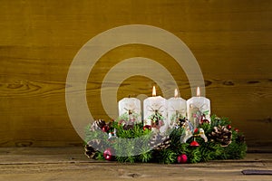 Advent wreath or crown with three burning white candles.