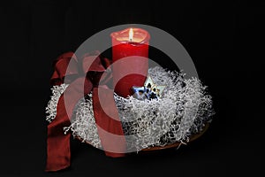 Advent wreath with one burning candle and red loop