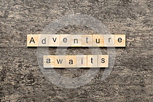 Adventure awaits word written on wood block. Adventure awaits text on cement table for your desing, concept