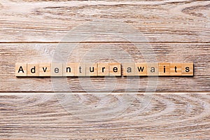Adventure awaits word written on wood block. Adventure awaits text on wooden table for your desing, concept