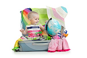 Adventure. Baby preparing for the journey. Child sits in suitcase and looks at globe.