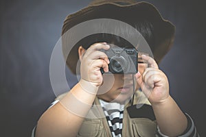 A adventure boy is preparing a camera and a binocular.