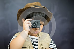 A adventure boy is preparing a camera and a binocular.