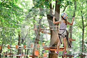 Adventure climbing high wire park - girl on course in mountain