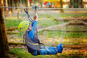 Adventure climbing high wire park - kid on course in helmet and safety equipment