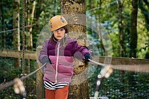 adventure climbing high wire park - kids on course in mountain helmet and safety equipment