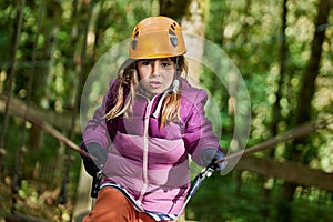 adventure climbing high wire park - kids on course in mountain helmet and safety equipment