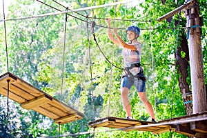 Adventure climbing high wire park - people on course in mountain helmet and safety equipment