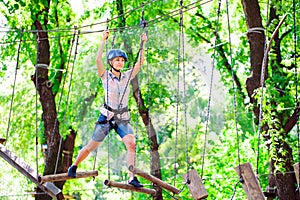Adventure climbing high wire park - people on course in mountain helmet and safety equipment